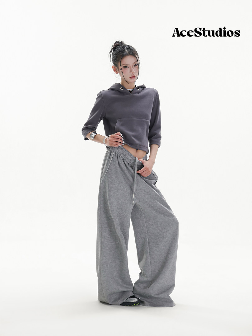 Model wearing a gray cropped hoodie and wide-leg sweatpants