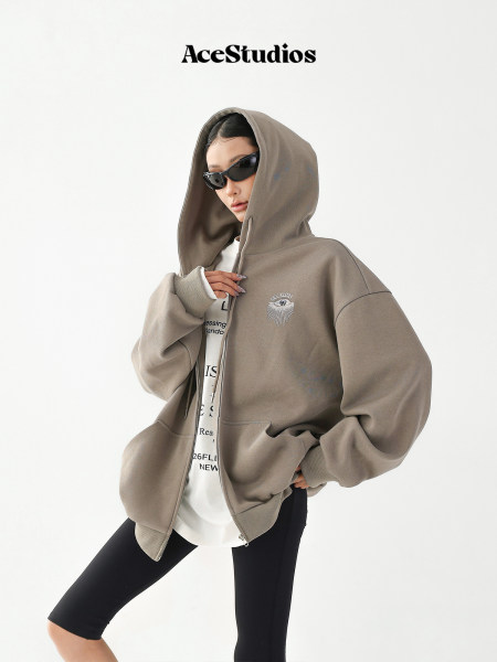 Model wearing an oversized zip-up hooded sweatshirt with black leggings