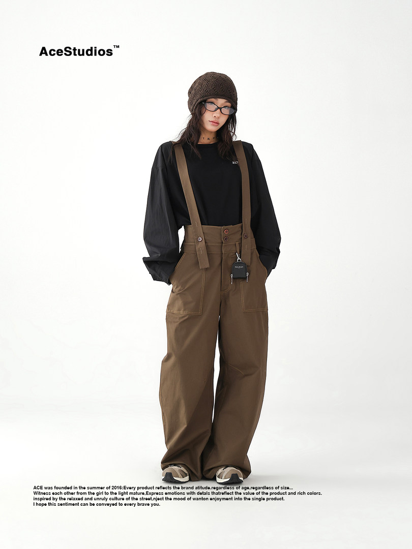 Model wearing a black top with brown high-waisted suspender pants and a knit beanie