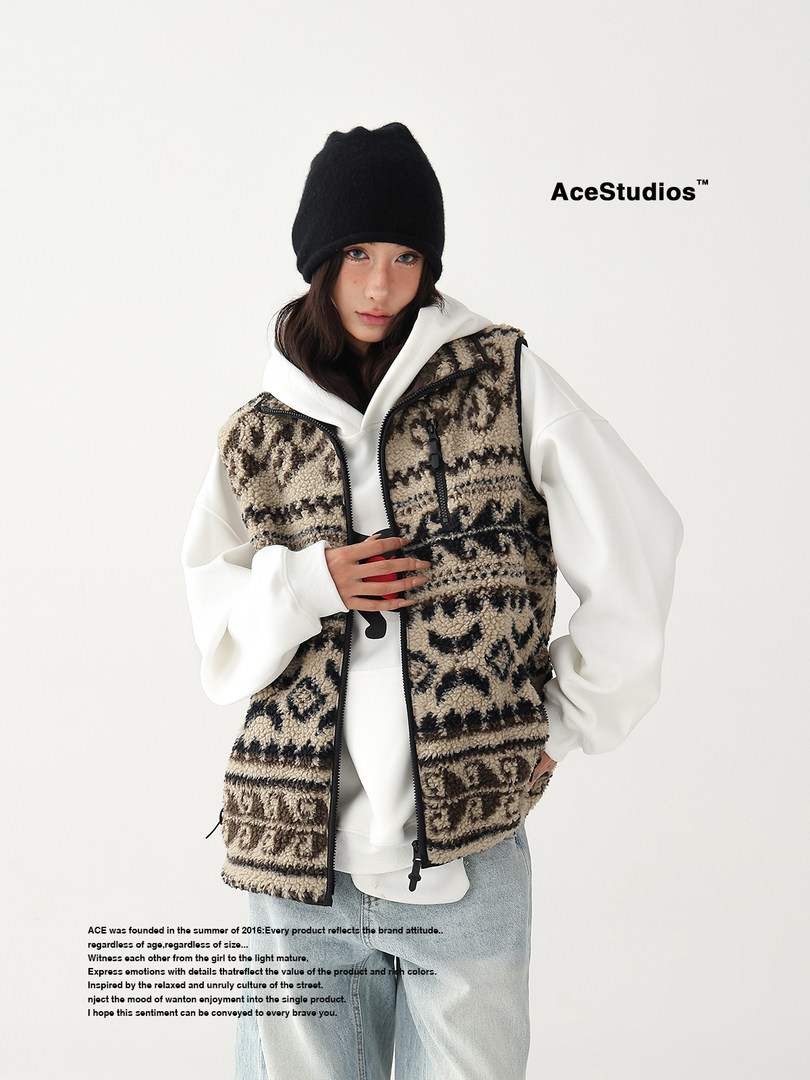 Model wearing a patterned fleece vest over a white hoodie with a black beanie