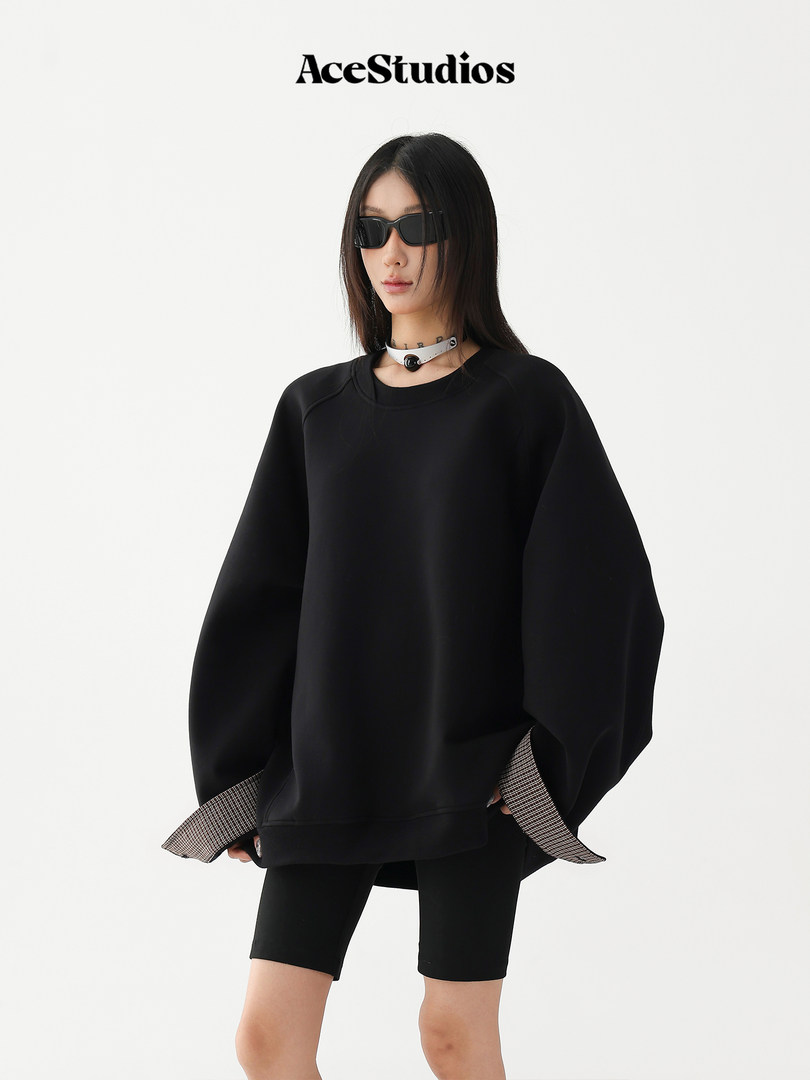 Model wearing an oversized black sweatshirt with biker shorts