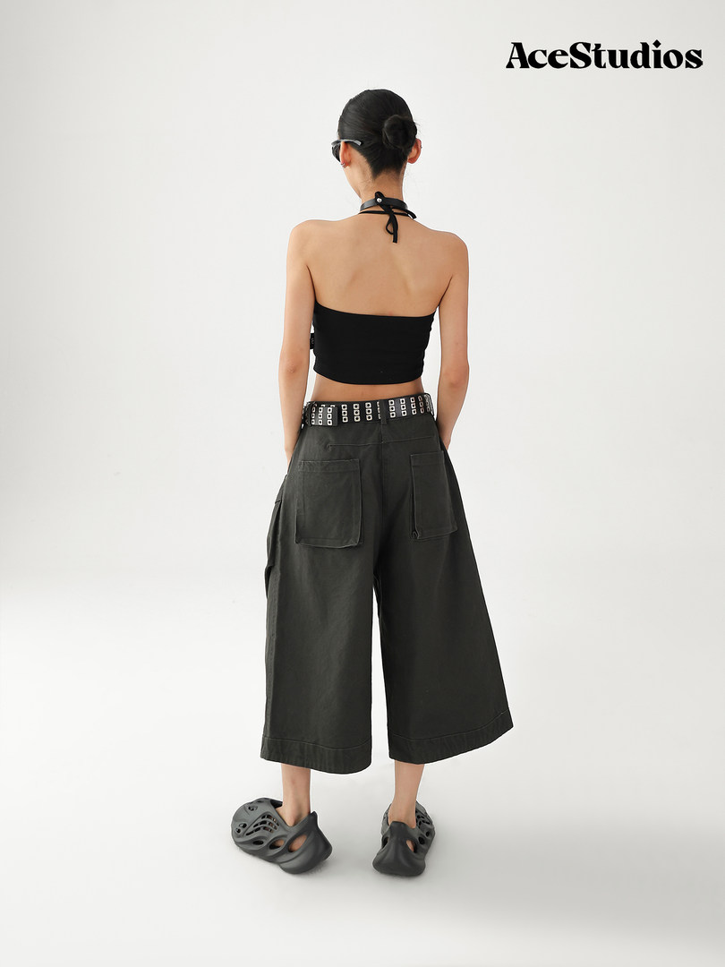 Model wearing a black halter crop top with wide-leg charcoal pants and chunky slip-on shoes