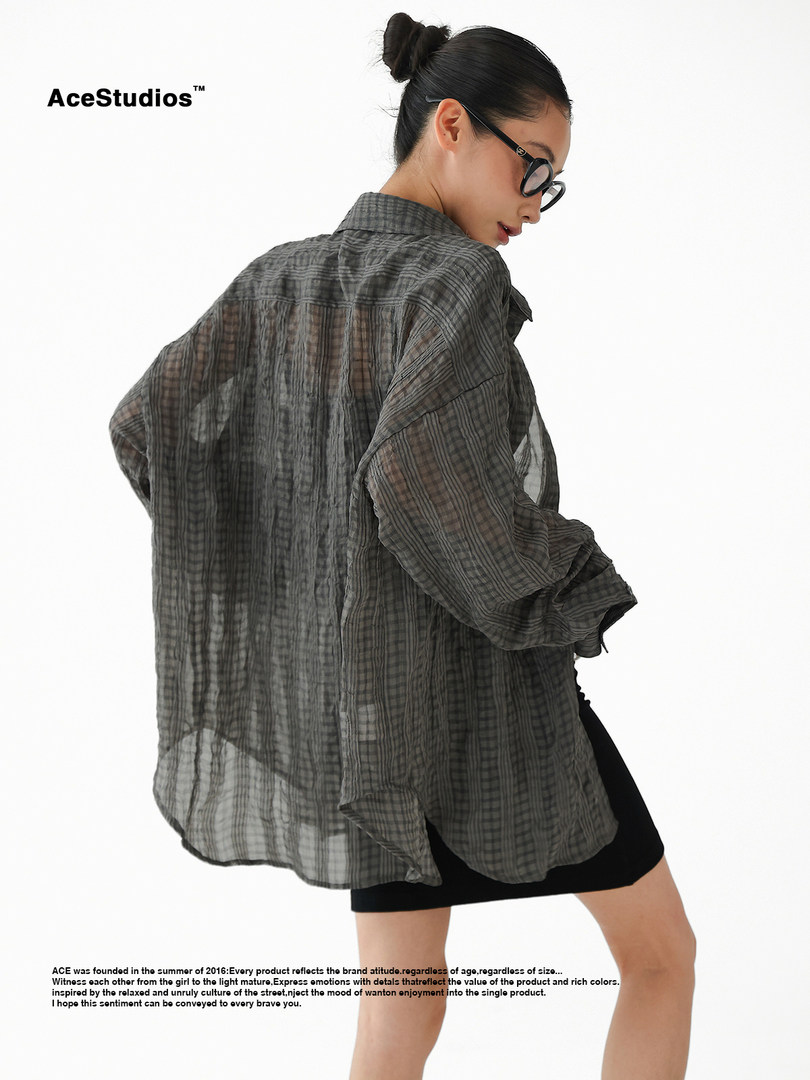 Model wearing a sheer gray plaid oversized shirt