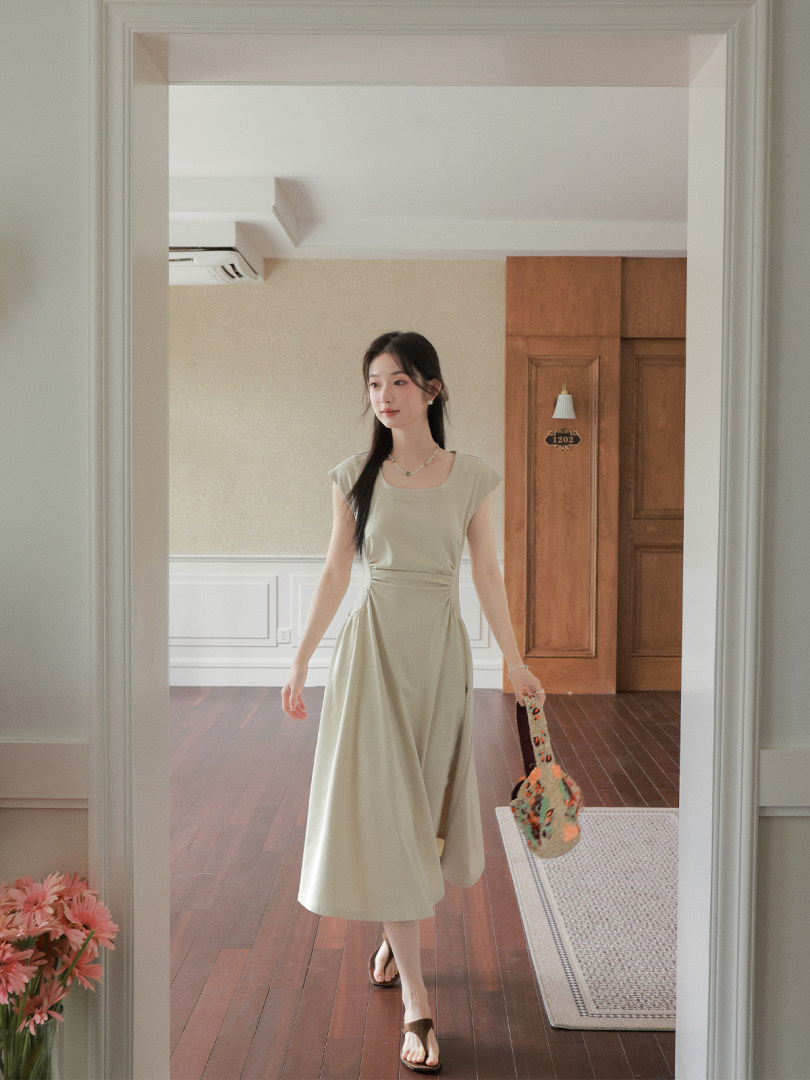 Model wearing a light beige sleeveless midi dress