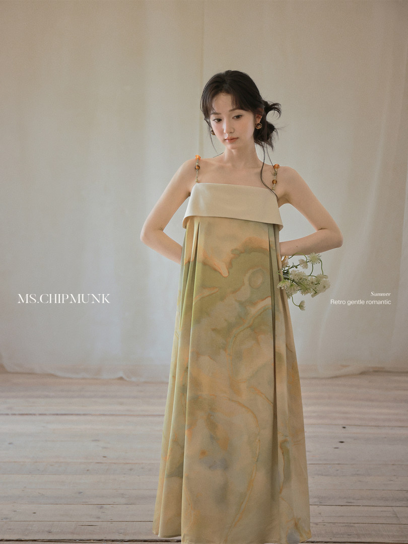 Model wearing a light pastel sleeveless maxi dress with floral print