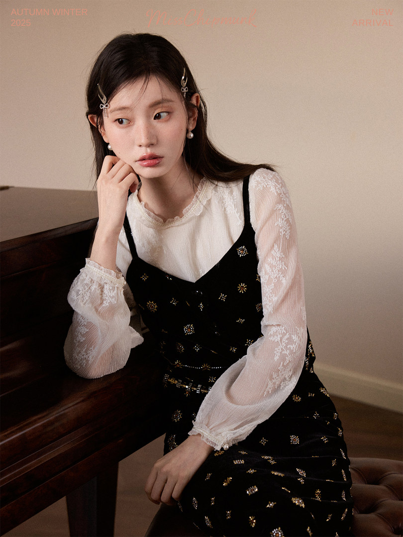 Model wearing a black embellished dress with a sheer white blouse