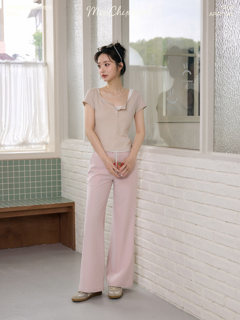 Model wearing a beige short-sleeve top and pink wide-leg pants