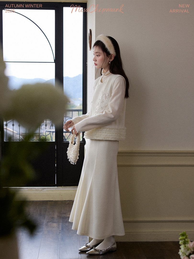 Model wearing a cream winter outfit with a long skirt and long-sleeve top