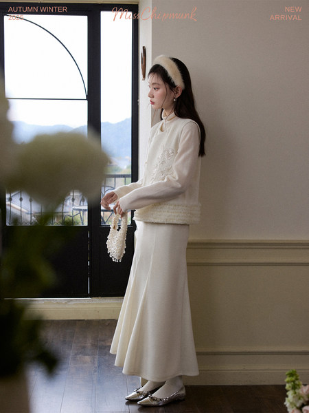 Model wearing a cream winter outfit with a long skirt and long-sleeve top