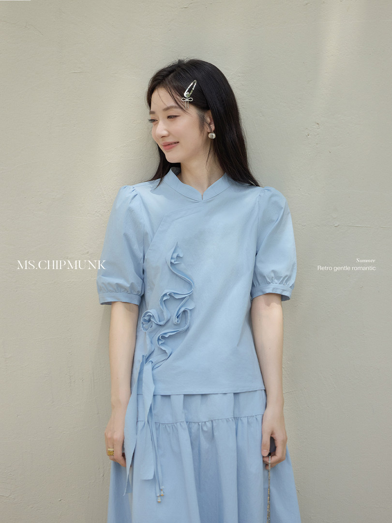 Light blue short-sleeve ruffled dress worn by a model
