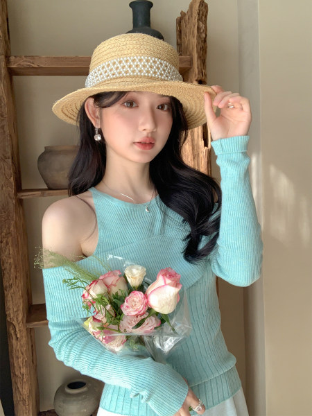 Model wearing a light blue ribbed off-shoulder top and straw hat with pearl trim