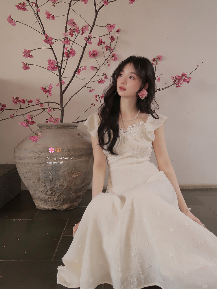 Woman wearing a white floral dress with ruffled sleeves