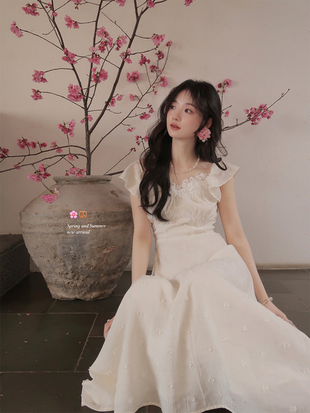 Woman wearing a white floral dress with ruffled sleeves