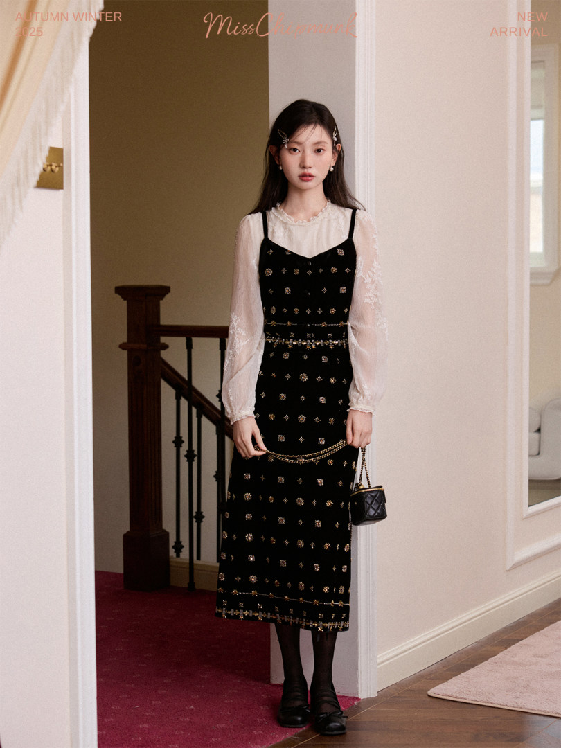 Model wearing a black embellished midi dress with a sheer white blouse