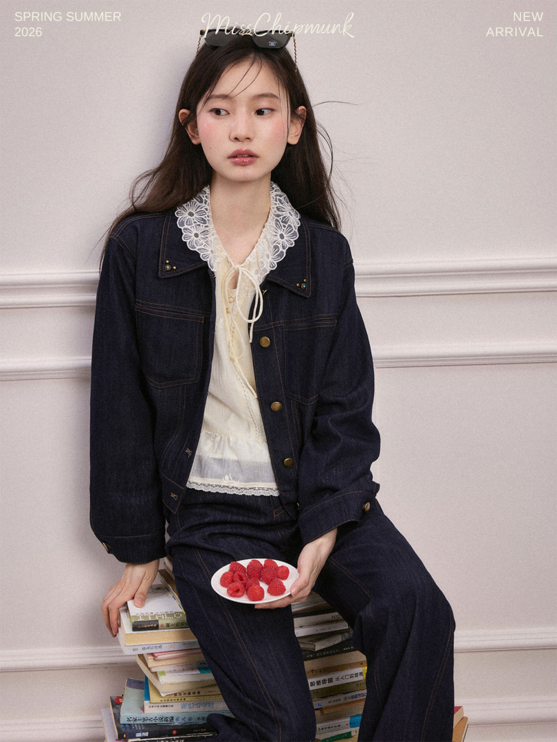 Model wearing a dark denim outfit with a lace-collar blouse