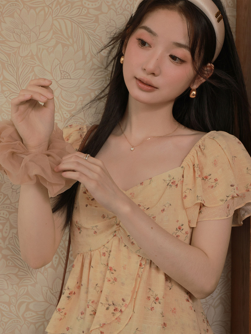 Model wearing a light yellow floral puff-sleeve dress
