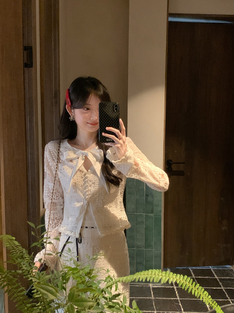Woman wearing a white lace two-piece outfit in a mirror selfie