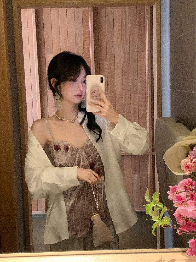 Woman wearing a velvet cami top with a light cardigan in a mirror selfie
