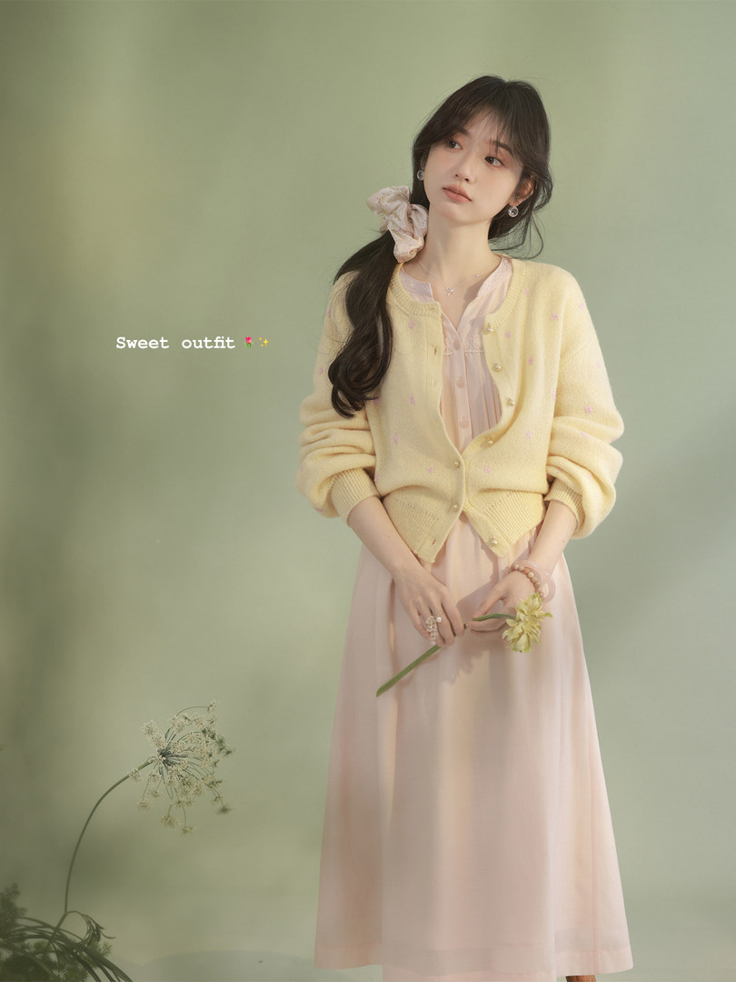 Pastel yellow cardigan over a pink dress on a model