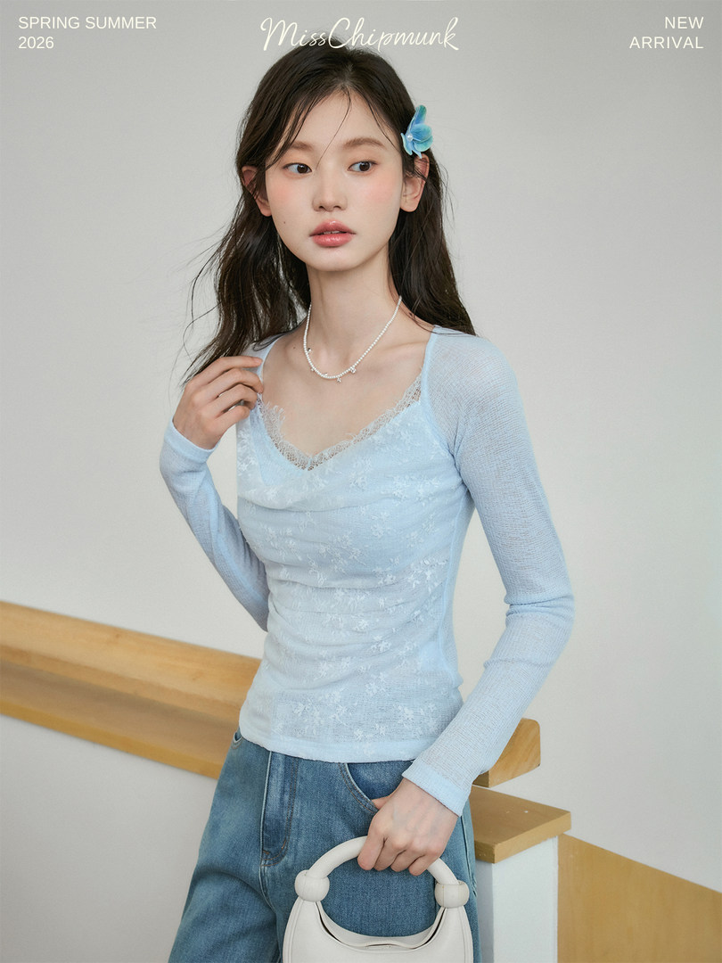 Model wearing a light blue lace long-sleeve top with jeans and a white handbag