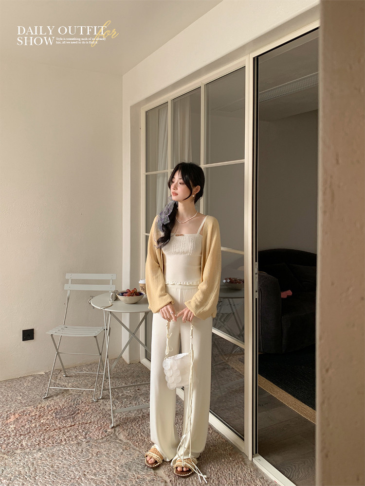 Model wearing a light cream cardigan and matching outfit indoors