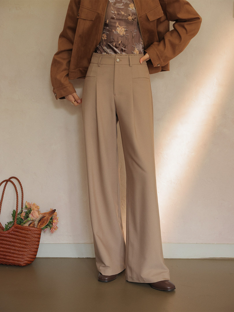 Beige wide-leg trousers worn with a brown jacket and floral top