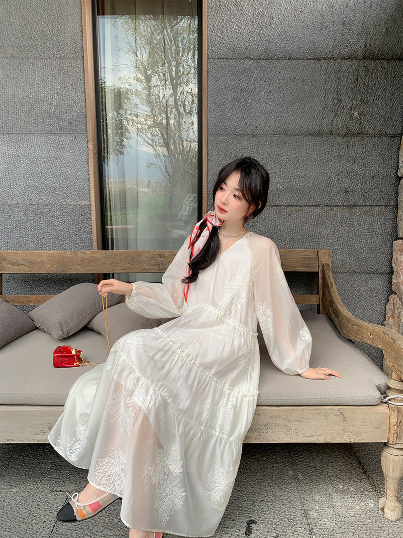 Woman wearing a white sheer embroidered long dress