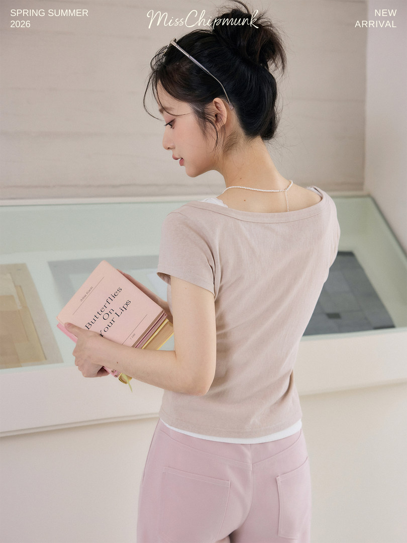 Model wearing a light beige fitted top and pastel pink pants