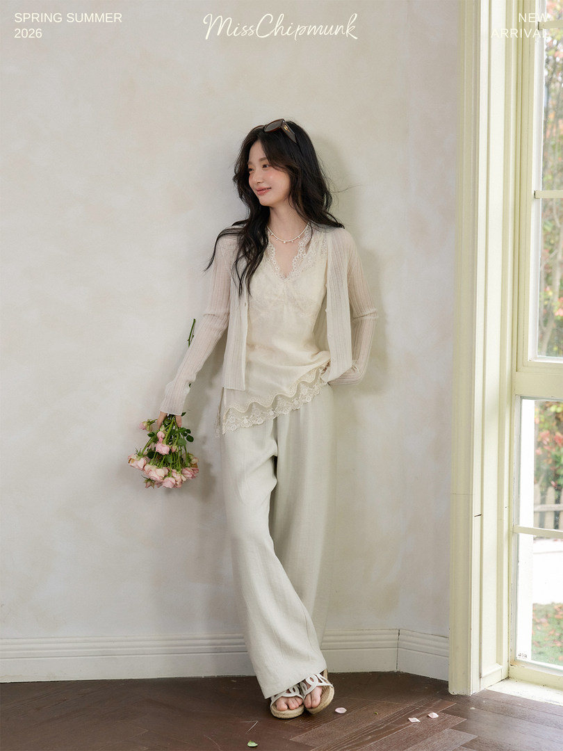 Woman modeling a cream lace-trimmed outfit with cardigan and wide-leg pants