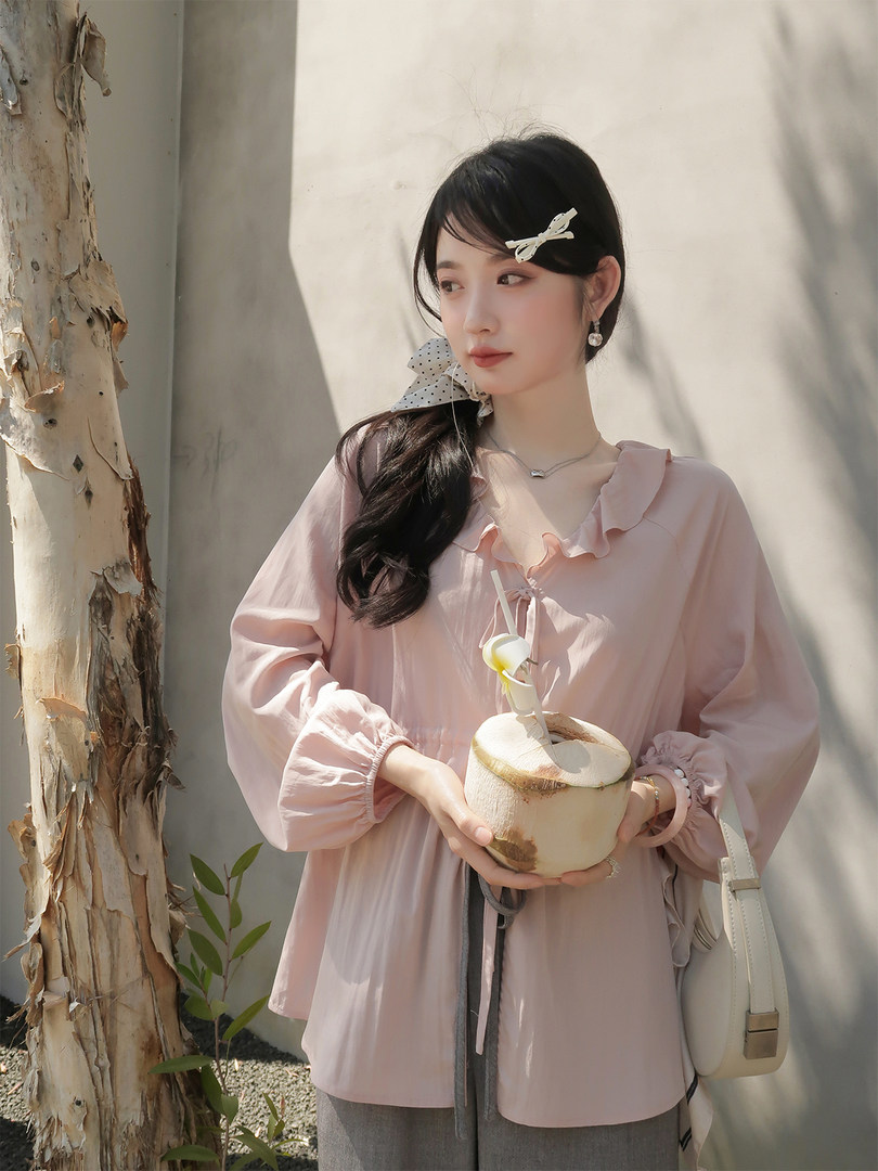 Woman wearing a light pink ruffled blouse