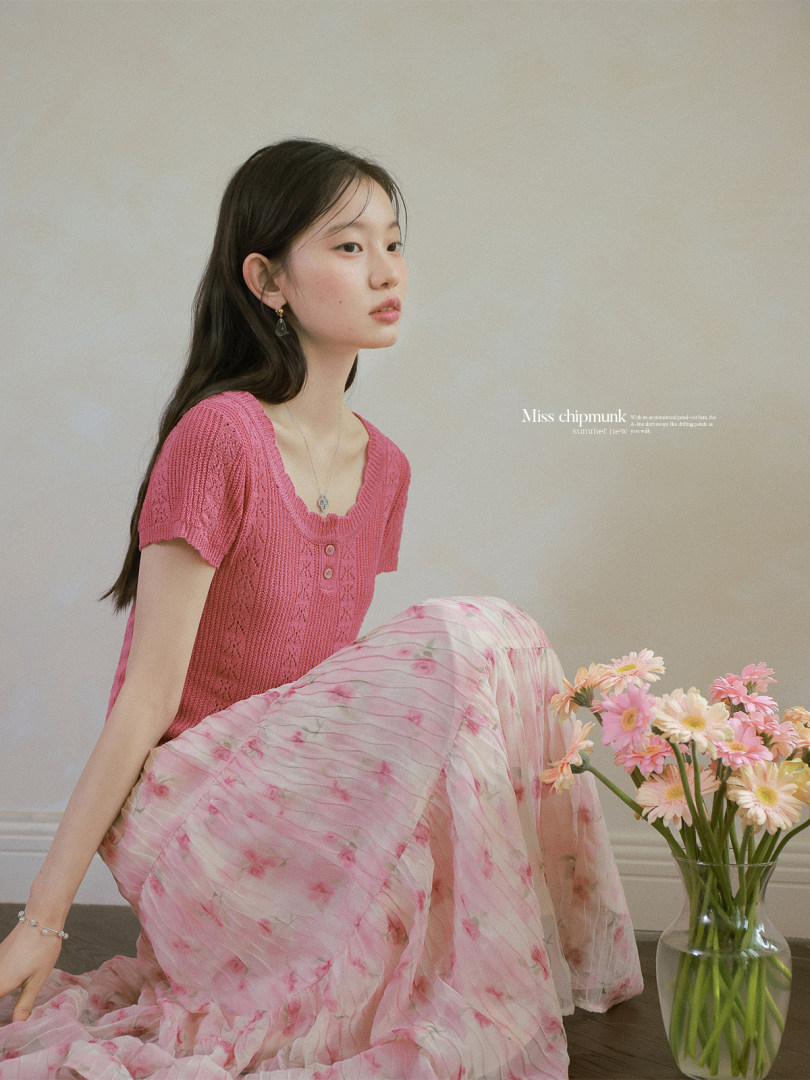 Model wearing a pink knit top and floral skirt