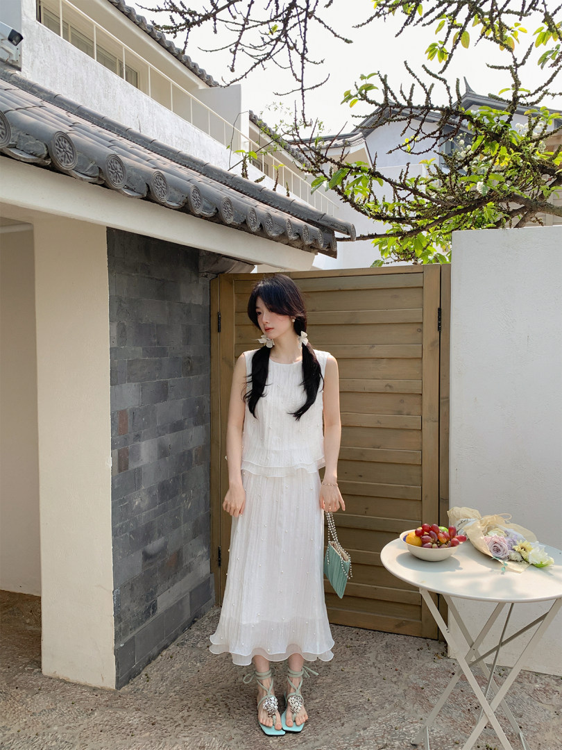 Woman wearing a white sleeveless dress outdoors