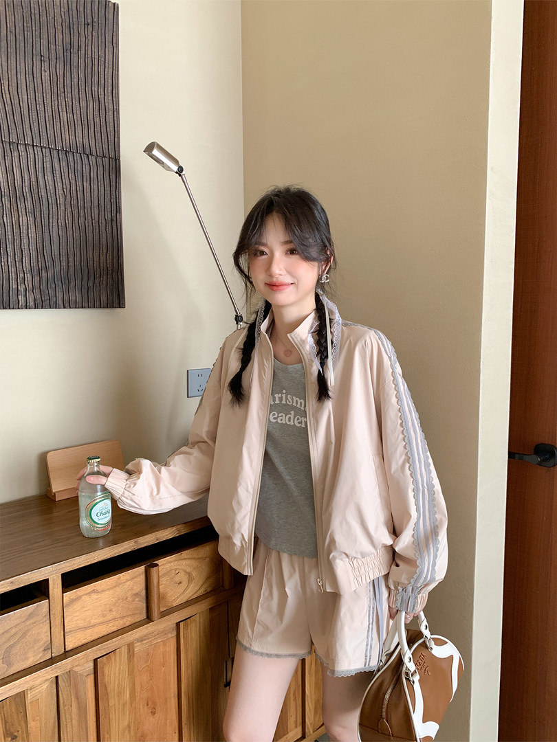 Model wearing a pale pink sporty jacket and shorts set