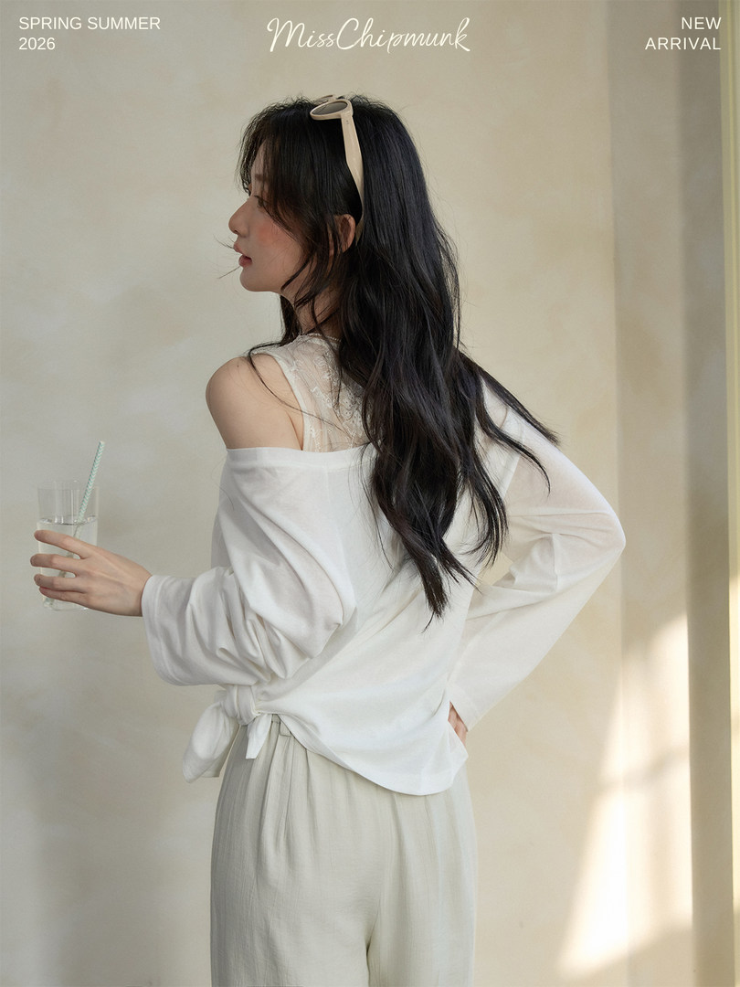 Model wearing a white off-shoulder top with light trousers