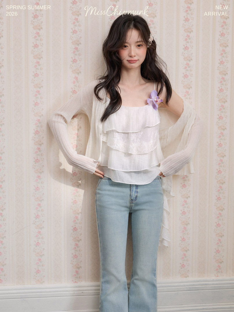 Model wearing a white layered camisole top with light blue jeans