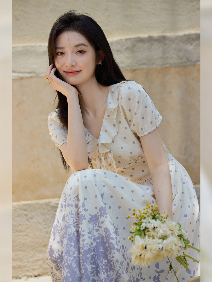 Woman wearing a light floral polka dot dress outdoors
