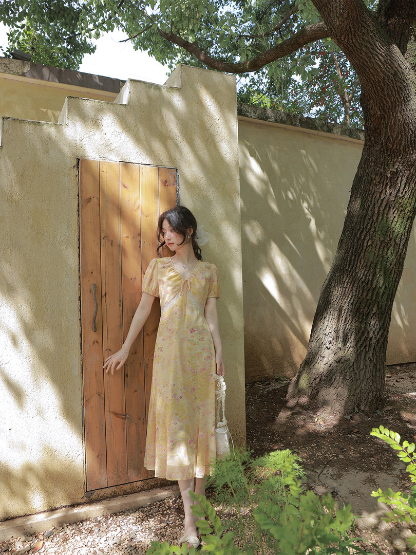 Woman wearing a yellow floral midi dress outdoors