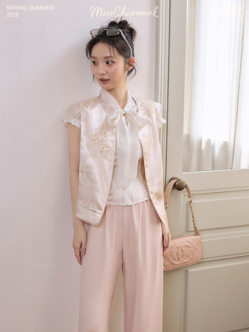 Young woman modeling a pastel pink feminine outfit with a satin vest and wide-leg pants