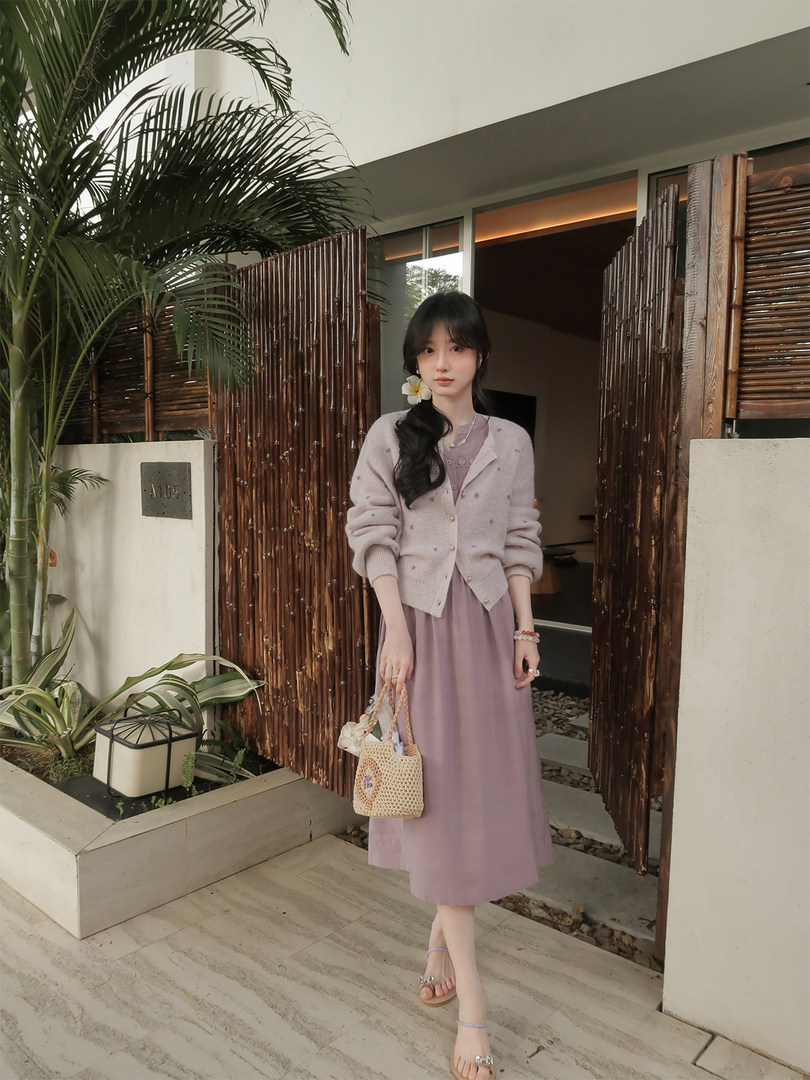 Model wearing a pastel cardigan over a lavender dress outdoors