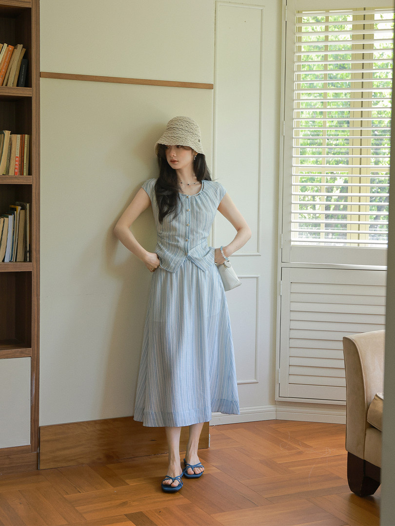 Light blue striped dress worn by a model indoors