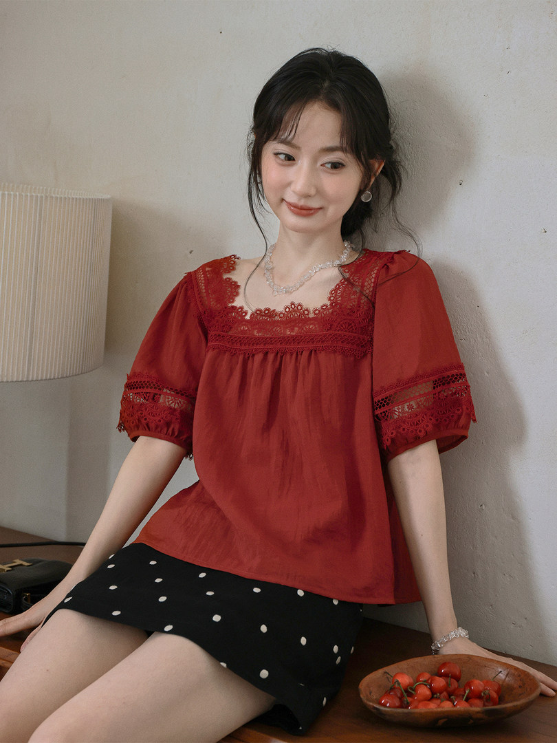 Red lace-trim short-sleeve blouse worn by a model with a black polka dot skirt