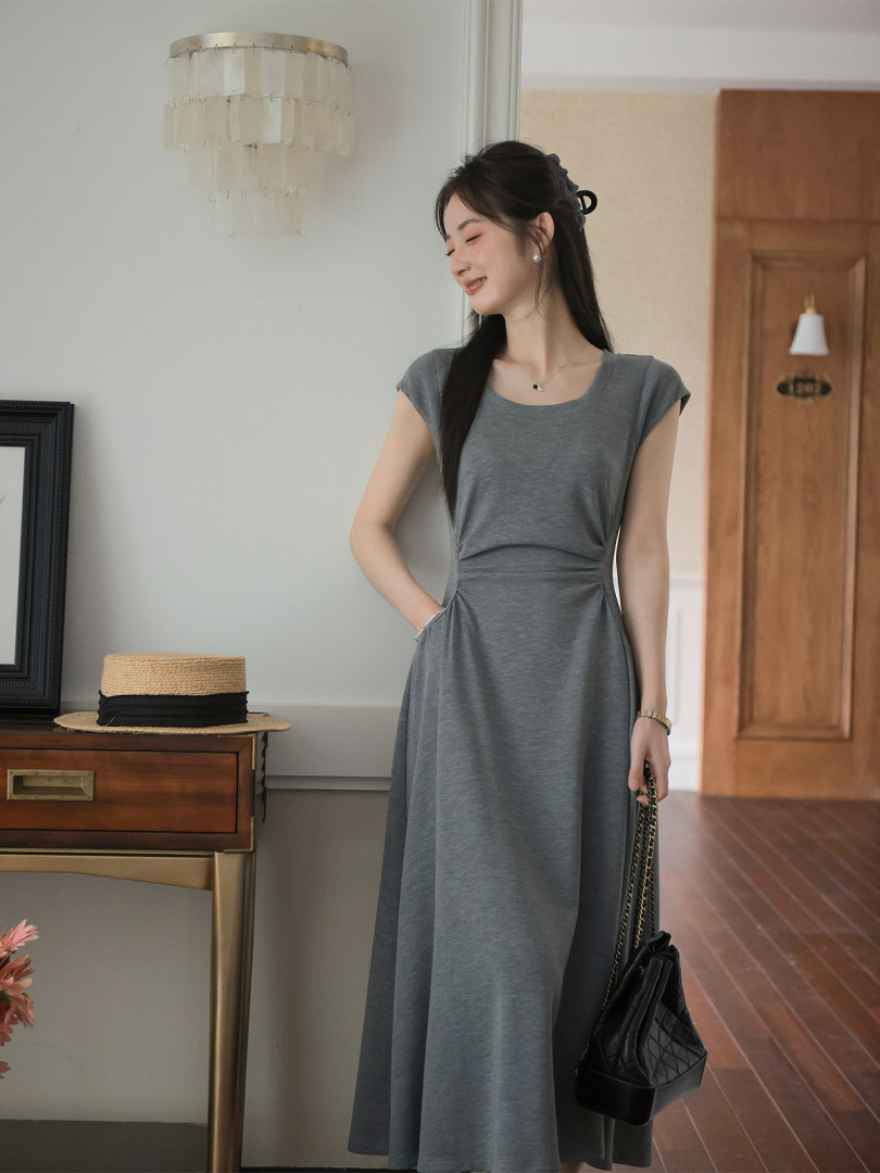 Gray sleeveless midi dress worn by a model indoors