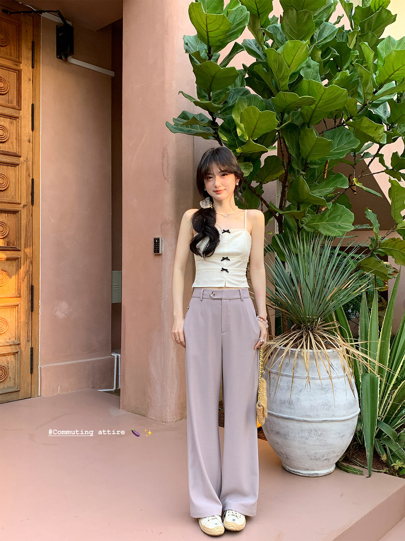 Model wearing a white sleeveless top with lilac wide-leg trousers outdoors