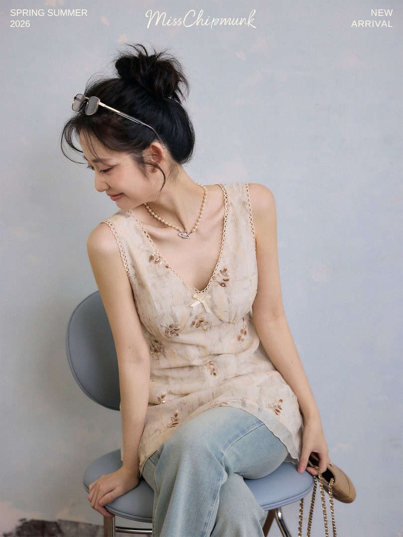 Model wearing a light floral sleeveless top and jeans