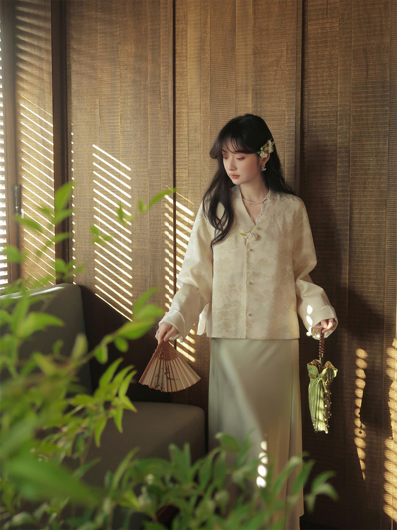 Woman wearing a cream traditional-style blouse and long skirt indoors