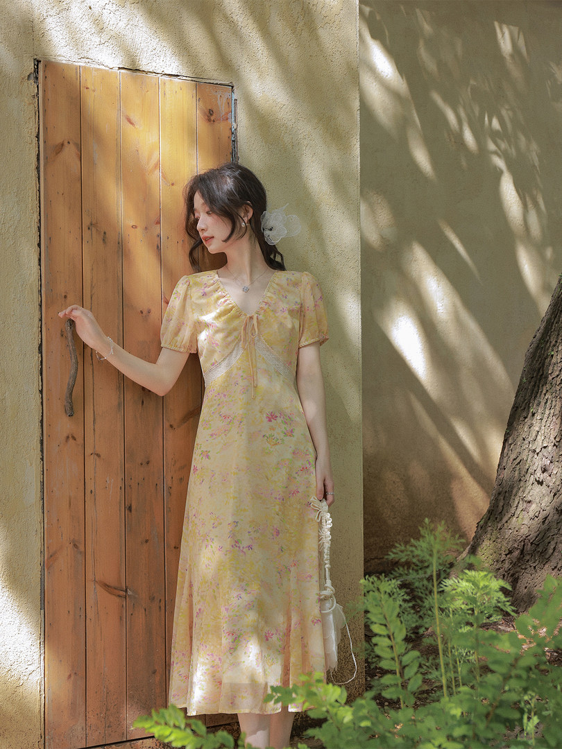 Woman wearing a yellow floral midi dress outdoors