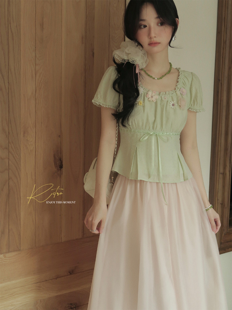 Pastel green and pink feminine dress outfit worn by a model