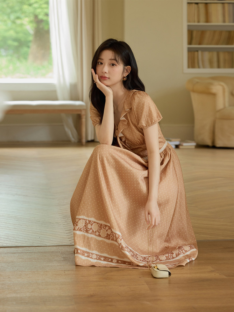 Woman wearing a peach flowy floral-print dress indoors