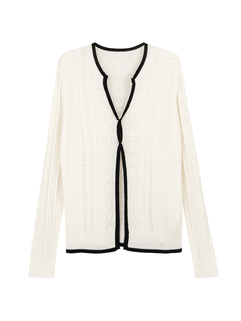White cable knit cardigan with black trim laid flat
