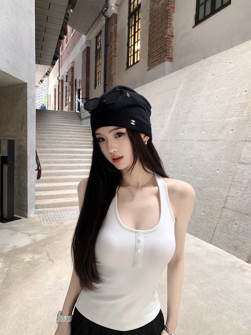 Woman wearing white ribbed tank top with buttons and black beanie with sunglasses on head
